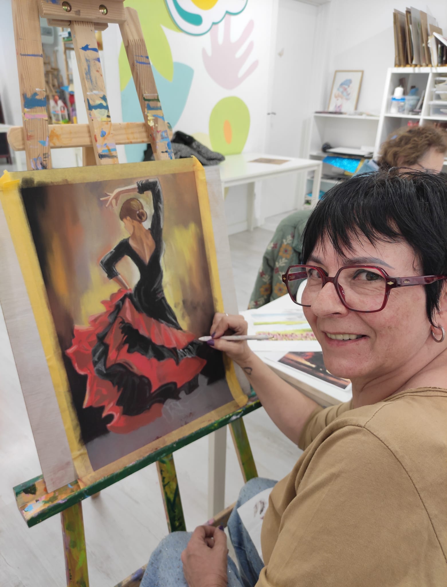 mujer pintando una chica con vestido de sevillana