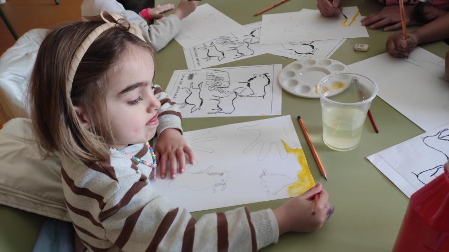 Niña pintando con cara de concentrada