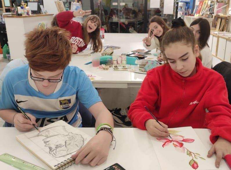 niño dibujando a lapiz y niña pintando en acuarela